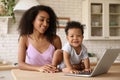 African-American woman and her baby with laptop. Happiness of motherhood Royalty Free Stock Photo