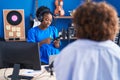 African american women musicians using smartphone at music studio