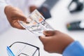 African american women pharmacist and customer paying for medicine with dollars at pharmacy