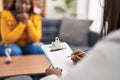 African american women psychologist and patient having mental therapy sitting on sofa at psychology clinic Royalty Free Stock Photo