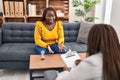 African american women psychologist and patient having mental therapy sitting on sofa at psychology clinic Royalty Free Stock Photo