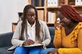 African american women psychologist and patient having mental therapy sitting on sofa at psychology clinic Royalty Free Stock Photo