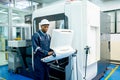 African American worker do some works with keyboard and monitor of controlling part of factory robot machine with safety
