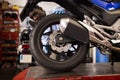 African american worker inspects the wheel of a motorcycle