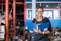 African american worker woman wear spectacles Ã¢â¬â¹holding clipboard standing in factory auto parts.