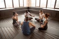 African-american yoga instructor talking to diverse group sittin