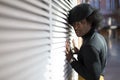 African American young adult male leaning on wall and looking at camera. Fashion model, retro aesthetic Royalty Free Stock Photo