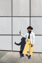 African American young adult male with retro look using a mobile phone in the street. Urban lifestyle