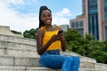 African american  young adult woman with mobile phone sending message Royalty Free Stock Photo