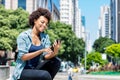 African american young adult woman sending sms message with phone Royalty Free Stock Photo