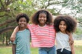 African American young girl smiling and  hugging with friends boy and girl in the park Royalty Free Stock Photo