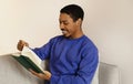 African American young man engrossed in literature, reading book indoor Royalty Free Stock Photo