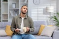 African American young man suffering from illness, flu, infection, runny nose at home. Sitting on the sofa and taking Royalty Free Stock Photo