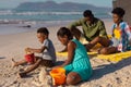 African american young parents sitting with son and daughter playing with pails and sand at beach Royalty Free Stock Photo