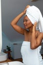 African american young woman adjusting her white head towel in bathroom at home, copy space Royalty Free Stock Photo