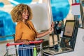 African American Young Woman with bank card buying food at grocery store or supermarket self-checkout Royalty Free Stock Photo