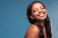African american young woman with beautiful toothy smile and delicate makeup over water drops Royalty Free Stock Photo
