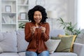 African American young woman holding a disposable home pregnancy test in her hands, looking at it and happy with a Royalty Free Stock Photo