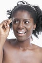 African American young woman tweezing her eyebrows over white background Royalty Free Stock Photo