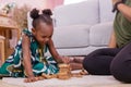 African Americans` mother and daughter playing block wooden games together in living room. black people or African Americans. Hom Royalty Free Stock Photo