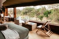 African - Asain Boho contemporary Tent camp lodge bedroom interior with natural wooden furniture and soft fabric bed