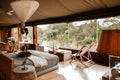 African - Asain Boho contemporary Tent camp lodge bedroom interior with natural wooden furniture and soft fabric bed