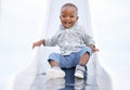 African baby, boy and slide at playground, portrait and excited for playing, learning and play in summer. Toddler, child