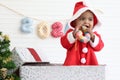 African baby kid in Santa Claus red costume standing in big gift box present at white room, beautiful little child celebrates