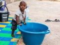 African baby wanting bathing in a basin in a poor suburb of Mbour Royalty Free Stock Photo