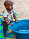 African baby wanting bathing in a basin in a poor suburb of Mbour