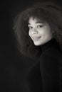 African beauty. Smiling young african-american woman in black clothes isolated on dark background Royalty Free Stock Photo