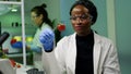 African biologist holding strawberry injected with dna liquid with medical tweezers Royalty Free Stock Photo