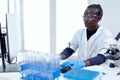 African biotechnology researcher works in bright modern laboratory