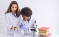 African black boy and caucasian girl studying science in classroom at school Royalty Free Stock Photo