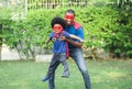 African black family spent time together in the home garden. Laughing father and son playing superhero at the day time. Happy Royalty Free Stock Photo