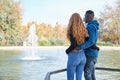 African black man and redhead caucasian woman backwards in a park