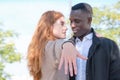 African black man and redhead caucasian woman showing an engagement ring to the camera and looking each other Royalty Free Stock Photo