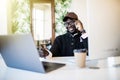 African black man talking on mobile cell phone to clients in office with laptop computer Royalty Free Stock Photo