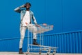 African black man walking with a shopping cart talking on the phone, making a phone call Royalty Free Stock Photo