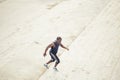 Side view of a male athlete running up staircase outside building Royalty Free Stock Photo