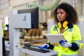 African black women worker work with wood cutter machine furniture factory industry with safety suit Royalty Free Stock Photo