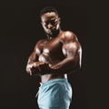 African bodybuilder showing biceps in black studio Royalty Free Stock Photo