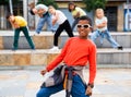 African boy dancing hip-hop with group of tweens on city street
