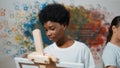 African boy painting canvas while girl draw cool tone picture. Edification. Royalty Free Stock Photo