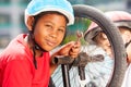 African boy repairing bicycle wheel with spanner Royalty Free Stock Photo