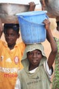 African boys carrying boxes with food on heads