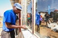 African builder installing windows on a Community Outreach program to build a small affordable house in local township