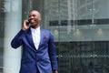 African business executive walking and talking on cell phone Royalty Free Stock Photo