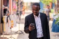 African business man using his phone and walking in the city Royalty Free Stock Photo