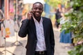 African business man using his phone and walking in the city Royalty Free Stock Photo